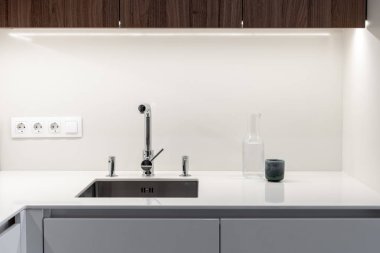 Yeni çağdaş mutfakta musluğu olan modern lavabo.