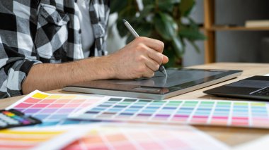 Ofiste grafik tabletle çalışan genç bir illüstratör
