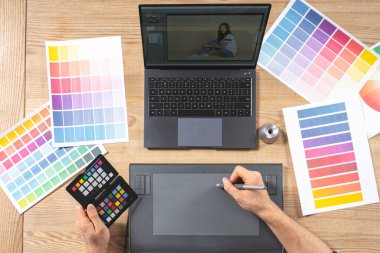 Ofiste grafik tabletle çalışan genç bir işçi.