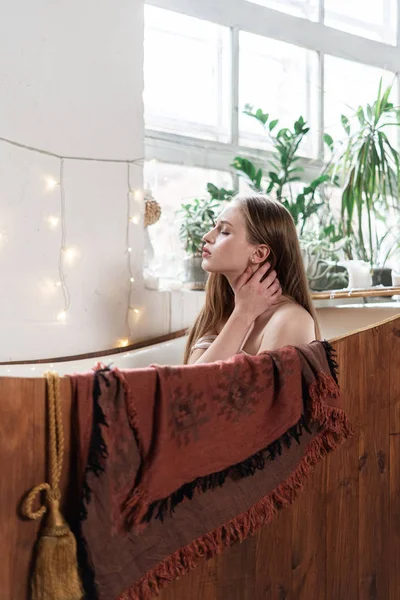 Jonge volwassen vrouw die thuis in bad gaat — Stockfoto