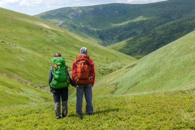Dağdaki doğa manzarasına bakan çift