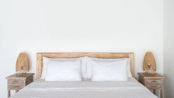 Затишне ліжко з плетеною нічною лампою на тумбочці в сучасному інтер'єрі будинку — стокове фото