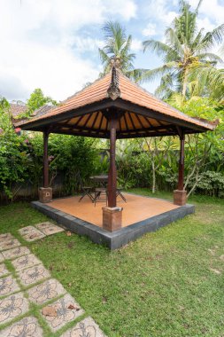 Metal sandalyeli ve arka bahçeli bir çardak.