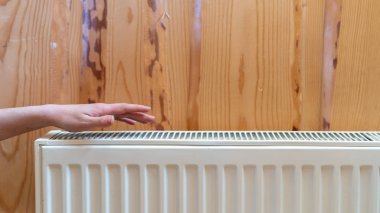 Evdeki ahşap duvarda rahat bir kalorifer var.