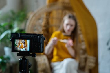 Genç yetişkin vlog kaydedicisi dslr kameraya video kaydediyor