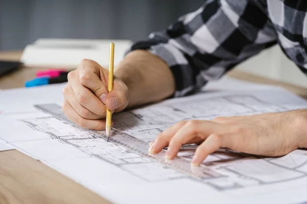 Arquitecto joven adulto hombre de negocios trabajando en estudio moderno con planos —  Fotos de Stock