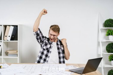 Profesyonel Büro 'da planlarla çalışan genç, yetişkin bir mimar.