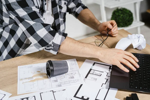 Young adult architect working with blueprints in workspace office — Stock Photo, Image