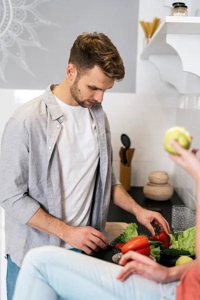 Молодые взрослые муж и жена стоят на современной кухне — стоковое фото