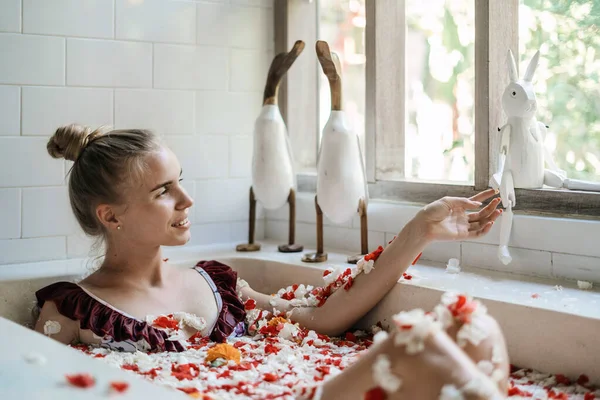 행복하고 미소짓는 소녀는 근처에 장식용 장난감으로 목욕을 아침을 화장실에서 보낸다 — 스톡 사진