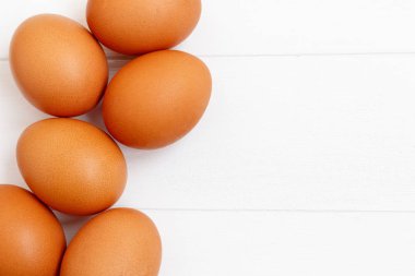 taze veya ham kahverengi yumurta beyaz ahşap zemin, üstten görünüm, fl