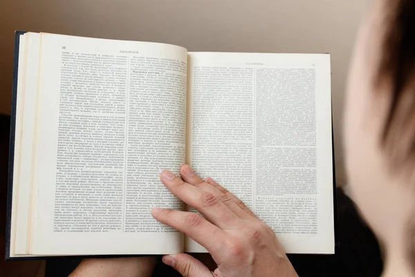 Joven sosteniendo libro y leyendo —  Fotos de Stock