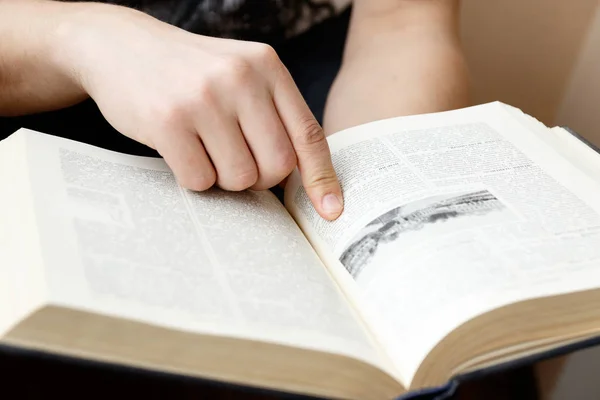 Joven sosteniendo libro y leyendo —  Fotos de Stock