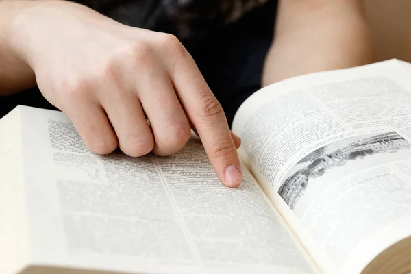 Joven sosteniendo libro y leyendo —  Fotos de Stock