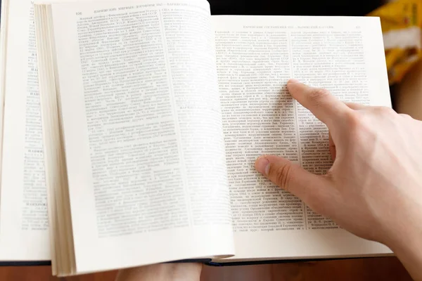 Joven sosteniendo libro y leyendo —  Fotos de Stock