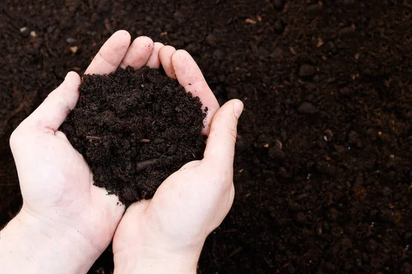 Hombre agricultor sosteniendo tierra. Día de la Tierra y concepto de ecología — Foto de Stock