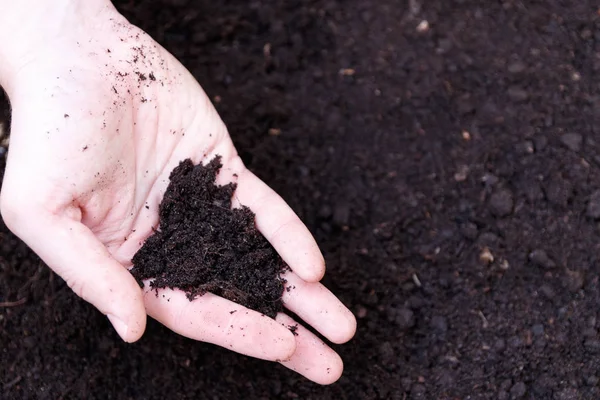 Hombre agricultor sosteniendo tierra. Día de la Tierra y concepto de ecología — Foto de Stock