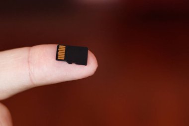 Mikro sd kart kopyalama spa kahverengi zemin üzerine insan parmak içinde