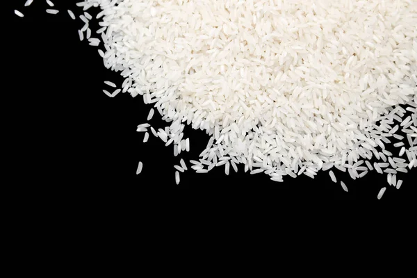 Ungekochter weißer Reis isoliert auf schwarzem Hintergrund. Ernährungskonzept — Stockfoto