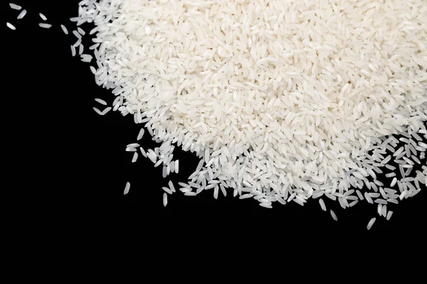 Ungekochter weißer Reis isoliert auf schwarzem Hintergrund. Ernährungskonzept — Stockfoto