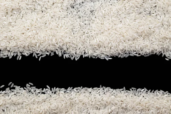 White rice scattered on black background. Copy space for your te — Stock Photo, Image