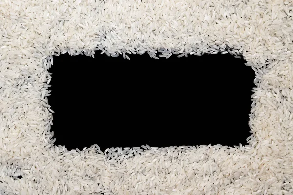 Witte rijst verspreid op zwarte achtergrond. Ruimte voor tekst in kopiëren — Stockfoto