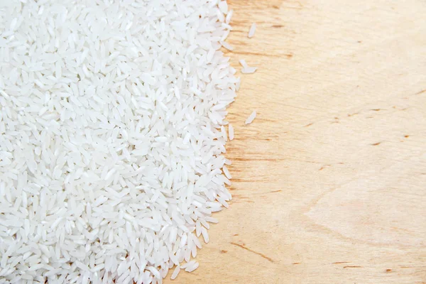 pile of white rice scattered on wooden texture