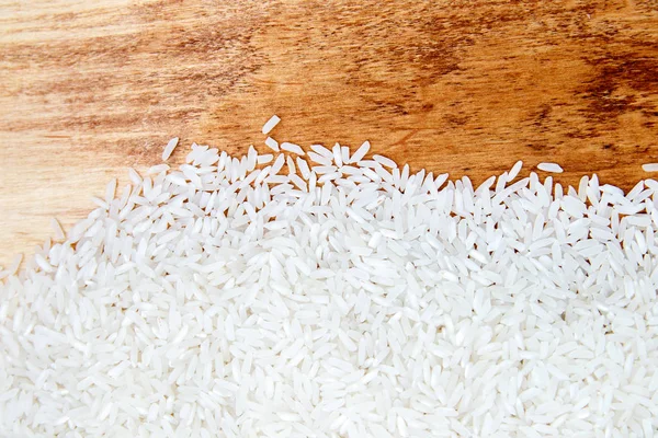 pile of white rice scattered on wooden texture