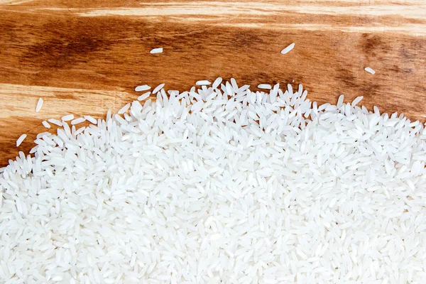Haufen weißer Reis auf Holzstruktur verstreut — Stockfoto