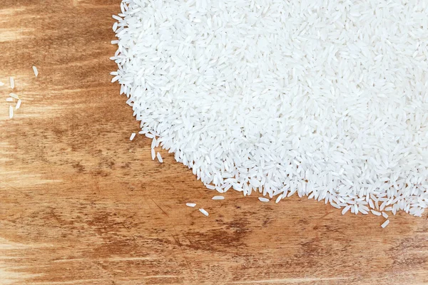 pile of white rice scattered on wooden texture