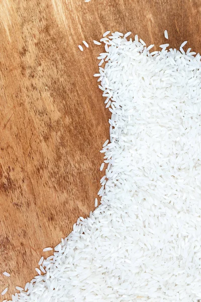 pile of white rice scattered on wooden texture