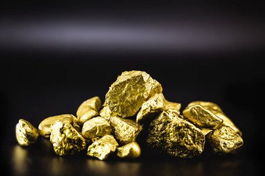 Golden nuggets isolated on black background. Luxury concept. clipart