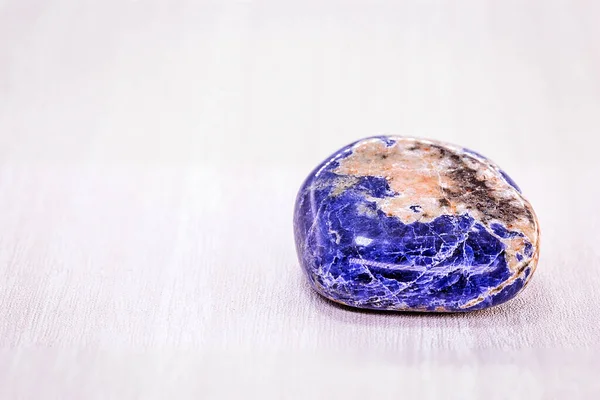 Mineralprov av lysande blå facetterad sten som kallas sodalite är en sällsynt mineral vanligtvis blå eller blåviolett färg, en sten som används i alternativa hälsobehandlingar. — Stockfoto