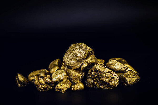 Golden nuggets isolated on black background. Luxury concept.