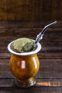 Gaucho yerba mate tea, the chimarrão, a typical Brazilian drink, traditionally in a bombilla stick cuiade gourd against a wooden background. Rio Grande do Sul, favorite drink of the gauchos.