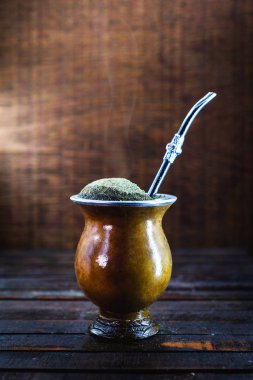 Gaucho yerba mate tea, the chimarrão, a typical Brazilian drink, traditionally in a bombilla stick cuiade gourd against a wooden background. Rio Grande do Sul, favorite drink of the gauchos.