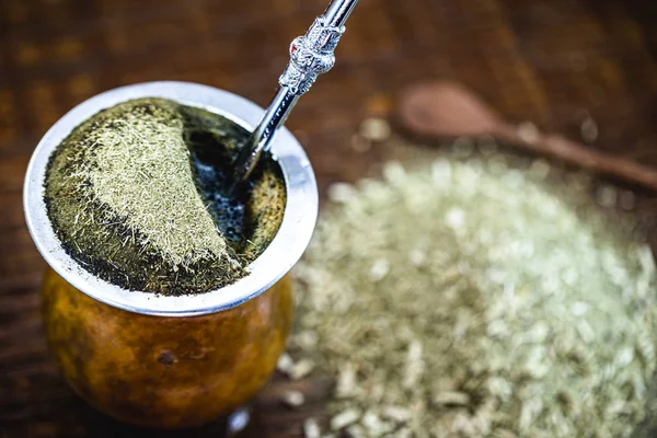 Gaucho yerba mate tea, the chimarrão, a typical Brazilian drink, traditionally in a bombilla stick cuiade gourd against a wooden background. Rio Grande do Sul, favorite drink of the gauchos. — Stok fotoğraf