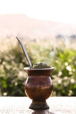 Chimarrão, traditional yerba mate tea from the state of Rio Grande do Sul. Selective focus. Typical drink with Serra Gaucha in the background.