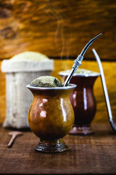 Єрба парує чай у калабаші на дерев'яному столі. Традиційний аргентинський, уругвайський та бразильський напій. Типовий напій з ріо гранде - ду - сул. — стокове фото