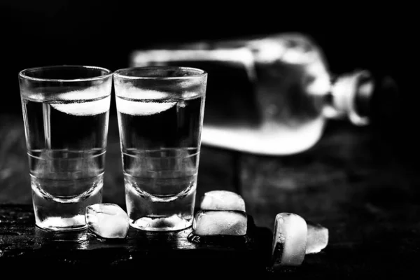 アルコール依存症化学物質依存症アルコール依存症は、物理的および感情的依存のためにアルコール摂取を制御することができないことである。黒と白、暗い写真のボトル. — ストック写真
