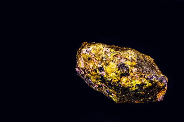 Uranmineral isoliert auf schwarzem Hintergrund. hochradioaktives und gefährliches Erz. — Stockfoto