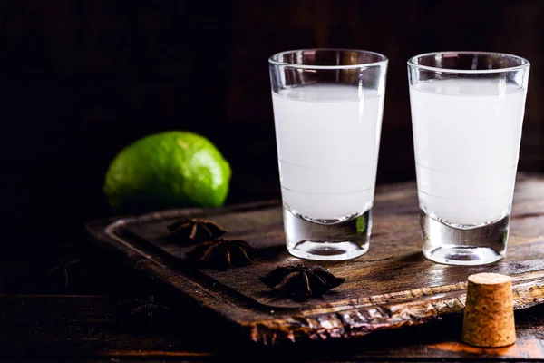 Ouzo o Uzo, es un brandy de anís griego, bebida alcohólica fuerte tradicional en vasos en la vieja mesa de madera. Tradición griega, bebida de los dioses. Lugar para el texto — Foto de Stock