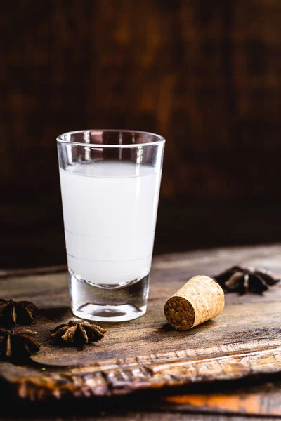 Ouzo або Uzo) - грецьке анізоване бренді, традиційний міцний алкогольний напій у склянках на старому дерев'яному столі. Грецька традиція, пийте богів. Місце для тексту — стокове фото