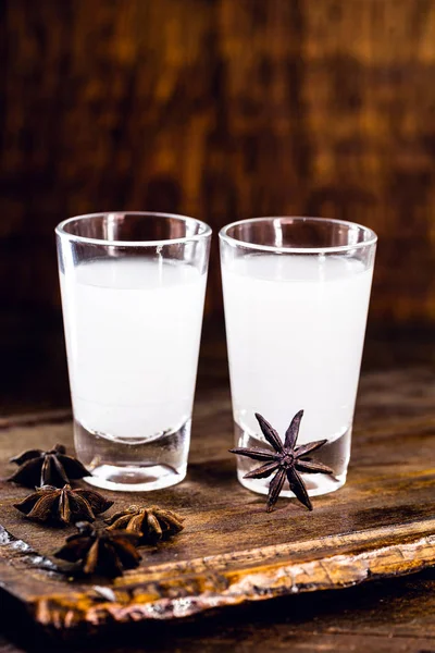 Ouzo oder Uzo, ist ein griechischer Anisschnaps, ein traditionelles starkes alkoholisches Getränk in Gläsern auf dem alten Holztisch. griechische Tradition, Göttertrank. Platz für Text — Stockfoto