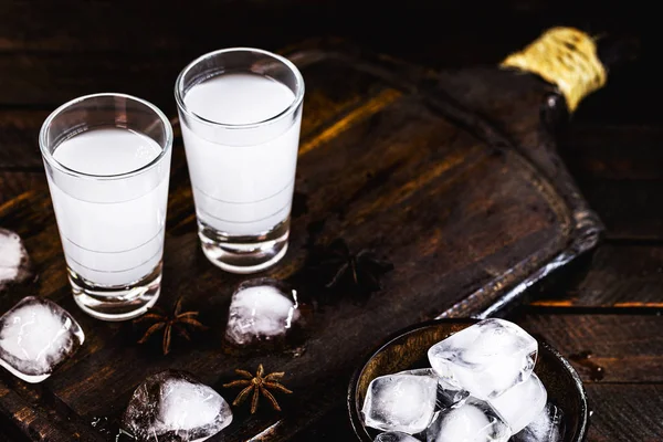 Bebida destilada, base de anís, sobre fondo de madera. Aperitivo tradicional turco y griego, conocido como Ouzo, Uzo, Raki, arak o raki árabe. Bebida turística . — Foto de Stock