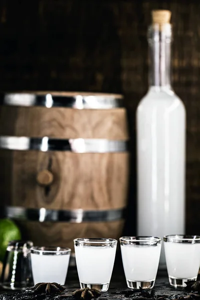Vodka griego tradicional, conocido como Uzo o ouzo en vasos de chupito sobre un fondo rústico de madera. Espacio para texto . — Foto de Stock