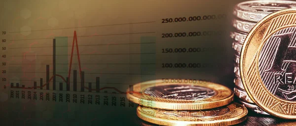 Brazilian money with market graph, concept of stock exchange and investments. Financial themed background, with real banknotes, money from brazil.