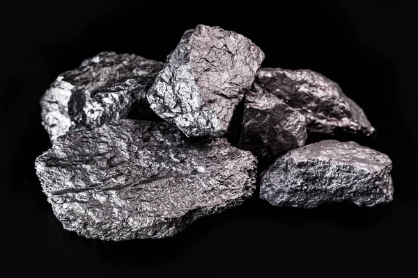 Nagy ezüst rögök fekete háttérrel. Nyers ezüst kő, ezüst rögök, Libériában őshonos, fekete háttérrel. Ásványkitermelés. — Stock Fotó