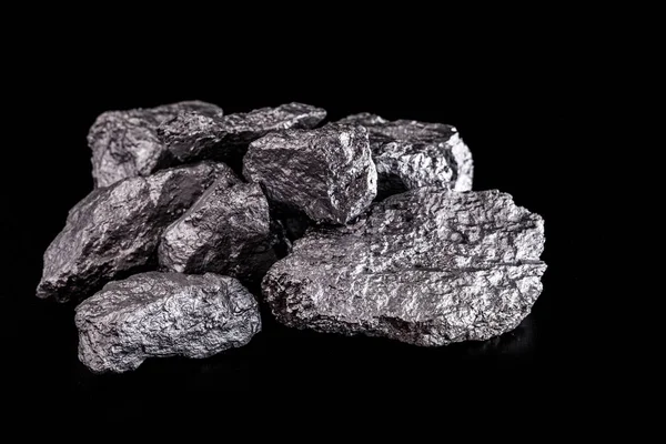 Nagy ezüst rögök fekete háttérrel. Nyers ezüst kő, ezüst rögök, Libériában őshonos, fekete háttérrel. Ásványkitermelés. — Stock Fotó
