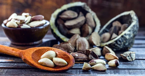 Foto de nueces de Brasil, conocida como castaña-da-amazjalá o castaña-do-acre. También se cultiva en Bolivia. Fondo de madera, con desenfoque, espacio para texto . — Foto de Stock